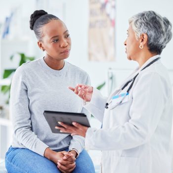 Doctor, woman and tablet for hospital, healthcare advice and support for results, exam and test on bed. Senior expert or medical people on digital tech for clinic sign up, registration and consulting